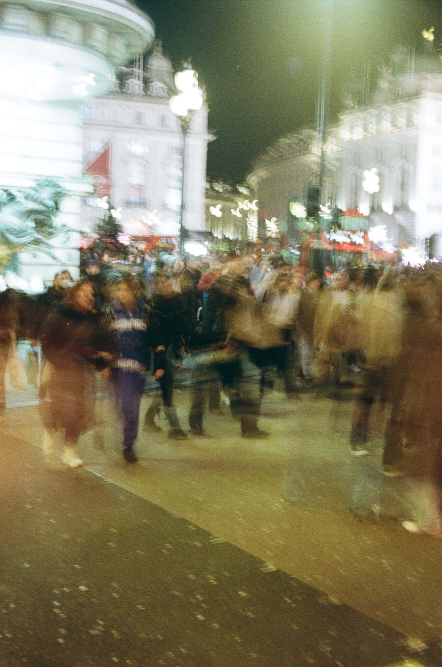 Motion-blurred crowd at Piccadilly Circus at night captured with long exposure on film